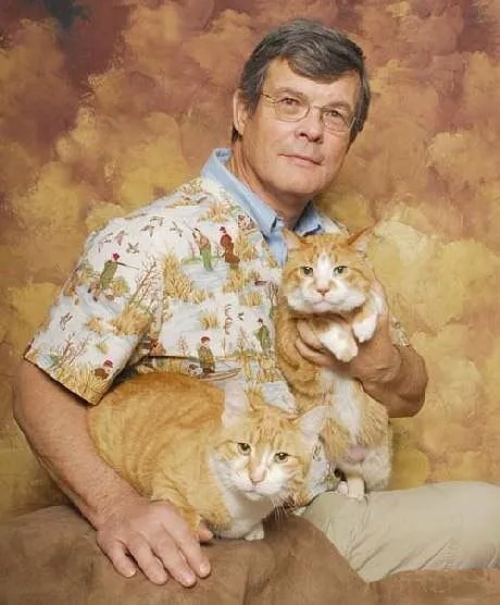 a person holding two cats